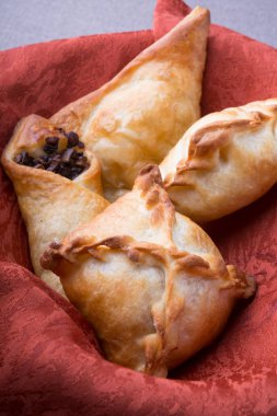 Farklı pişmiş pirogi veya samosa bir sepet içinde servis