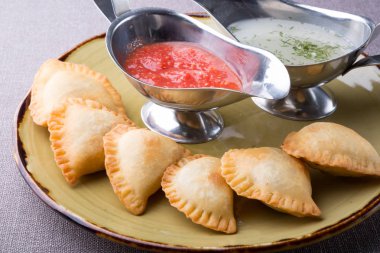 Soslar ile bir tabakta et küçük pirogi dolması