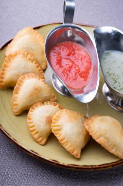 Soslar ile bir tabakta et küçük pirogi dolması