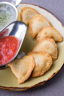 Soslar ile bir tabakta et küçük pirogi dolması