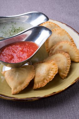 Soslar ile bir tabakta et küçük pirogi dolması