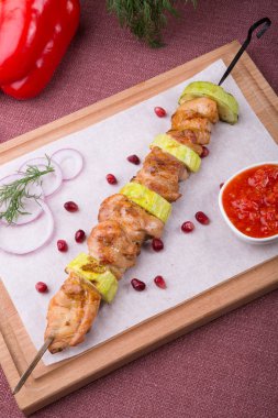 Metal şiş üzerinde ızgara et ahşap tahta üzerinde sos ile servis