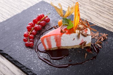 Dilim cheesecake ile kırmızı kuş üzümü hizmet