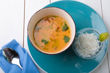 Beyaz ahşap bir masa üzerinde pirinç ile Tom yum Tay çorba servis