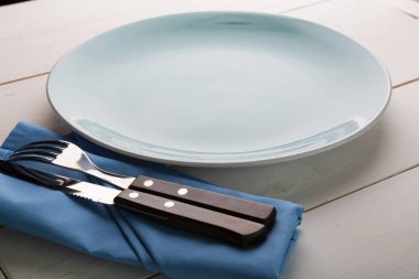 Ahşap masa öğle yemeği için boş tabak çatal bıçak takımı ile hizmet