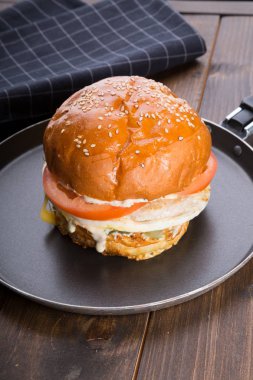 Ahşap masa üzerinde küçük bir tavada servis hamburger