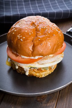 Ahşap masa üzerinde küçük bir tavada servis hamburger