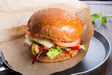 Ahşap masa üzerinde küçük bir tavada servis hamburger