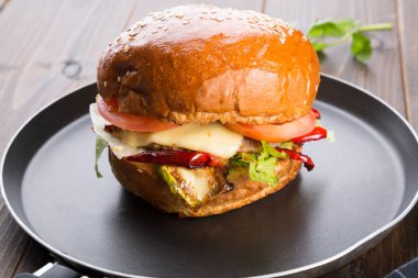 Ahşap masa üzerinde küçük bir tavada servis hamburger