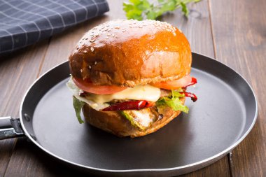 Ahşap masa üzerinde küçük bir tavada servis hamburger