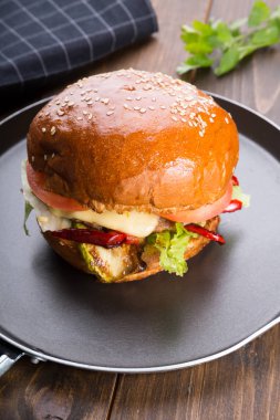 Ahşap masa üzerinde küçük bir tavada servis hamburger