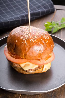 Ahşap masa üzerinde küçük bir tavada servis hamburger