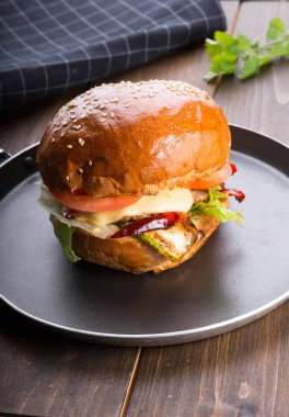 Ahşap masa üzerinde küçük bir tavada servis hamburger