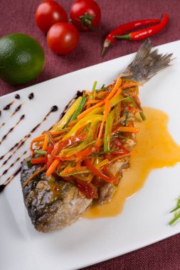 Bir tabakta sebze ile pişmiş dorado balık buğulama