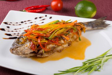 Bir tabakta sebze ile pişmiş dorado balık buğulama