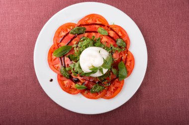 İtalyan burrata peyniri dilimlenmiş domates ve pesto ile servis