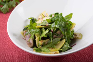 Sığır dili ve beyaz bir kase içinde elma yeşil Roka Salatası