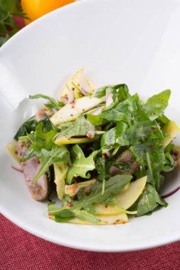 Sığır dili ve beyaz bir kase içinde elma yeşil Roka Salatası