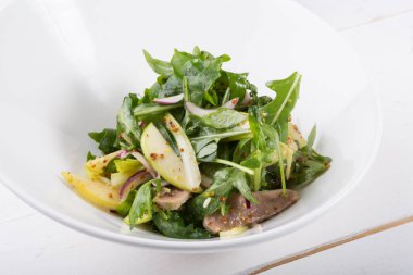 Sığır dili ve beyaz bir kase içinde elma yeşil Roka Salatası