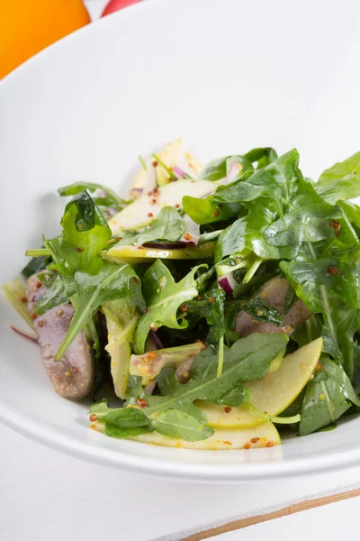 Salade de roquette verte avec langue de bœuf et pomme dans un bol blanc — Photo