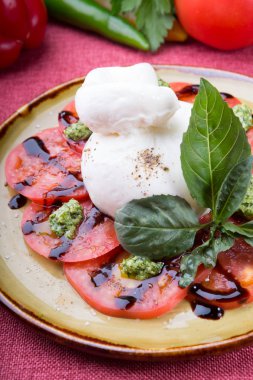 Bufalo burrata peyniri taze çiğ domatesle servis edilir.