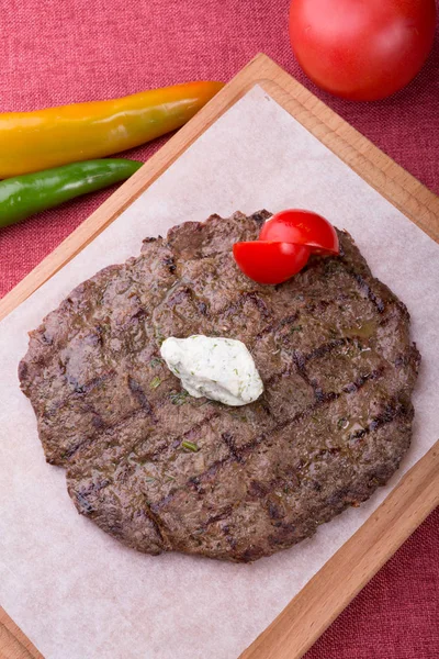 Fried horse meat steak served on wooden board