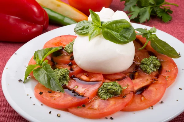 Bufalo burrata peyniri taze çiğ domatesle servis edilir.