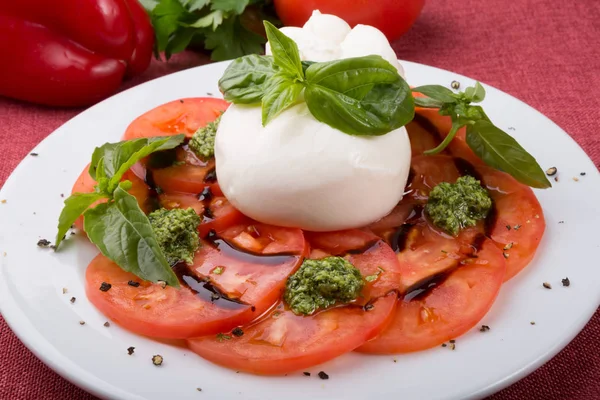 Bufalo burrata peyniri taze çiğ domatesle servis edilir.