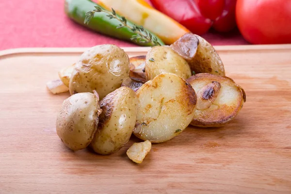 Fried potatoes served on wooden chopping board — Stock Photo, Image