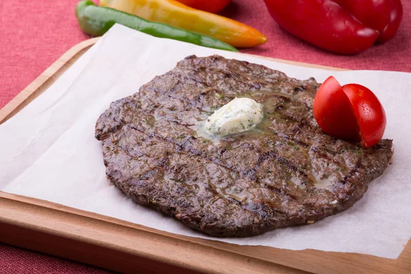 Fried horse meat steak served on wooden board