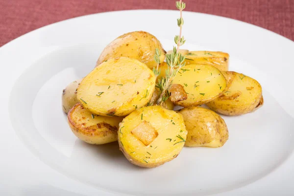 Baked yellow potatoes as garnish served with thyme — Stock Photo, Image