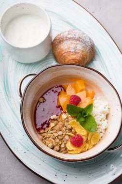 Kruvasan ile servis edilen sağlıklı kahvaltı kase