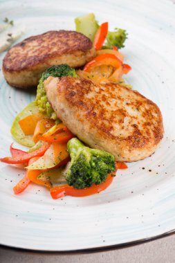 Buğulanmış sebzelerle servis edilen et pirzolaları