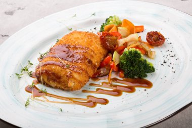 Izgara sebzelerle servis edilen ekmekli balık pirzama