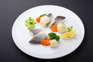 Buğulanmış balık filetosu ve sebze tabağı.