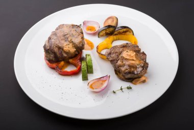 Beyaz tabakta ızgara sebzeli biftek.