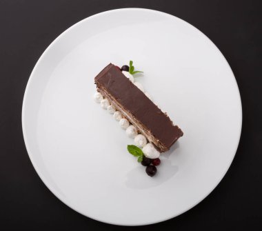 Beyaz tabakta servis edilen bir parça çikolatalı pasta.