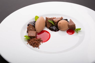 Beyaz tabakta siyah çikolatalı trüf mantarı.