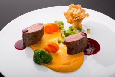 Sos ve buharda pişirilmiş sebzelerle servis edilen et karışımları.