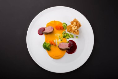 Sos ve buharda pişirilmiş sebzelerle servis edilen et karışımları.