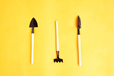 Aletler, aletler ve çiftlik aletleri ya da sarı arka plandaki ev aletleri. Üst Manzara. Metin için boşluk.