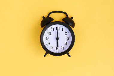 Yukarıdan mavi arkaplanda siyah alarm saatini göster. Sabah 6..