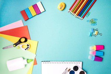 Mavi arka planda okul malzemeleri. Okul konseptine geri dönelim. Merkezde mesaj için yer var. Eğitim