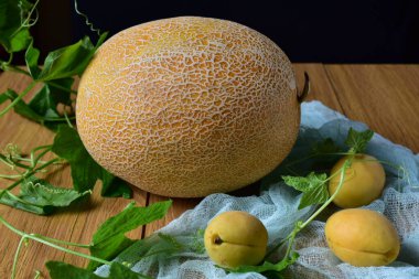 Masada yaprakları ve kayısıları olan kavun.