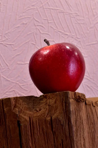Maçã vermelha em um suporte de madeira — Fotografia de Stock