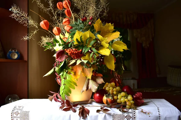 Nature morte avec des fruits et un bouquet de feuilles d'automne et de baies. — Photo