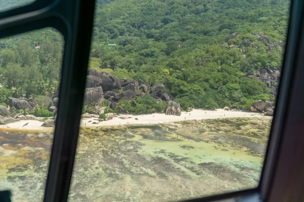 Aerial view in helicopter cabin of the tropical la digue Island. top view of famous anse source d\'argent