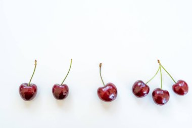 Düz kompozisyon ve beyaz masa üzerinde tatlı kirazlar. Metin için boşluk ile panoramik görünüm