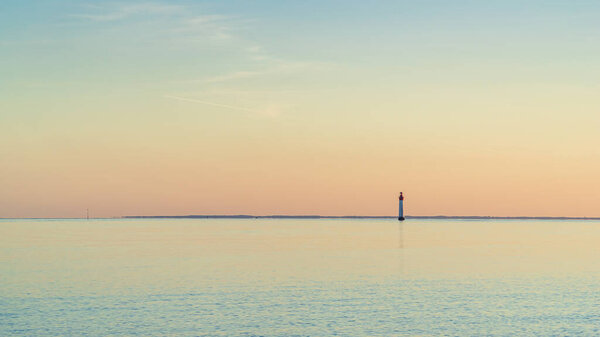 Chassiron lighthouse, isle of Re, at sunset on a very calm sea. beautiful minimalist seascape