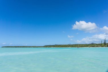 Upi Körfezi 'nin güzel deniz manzarası, Pines Adası, Yeni Kaledonya: Turkuaz lagünü, yemyeşil bitki örtüsü, mavi gökyüzü